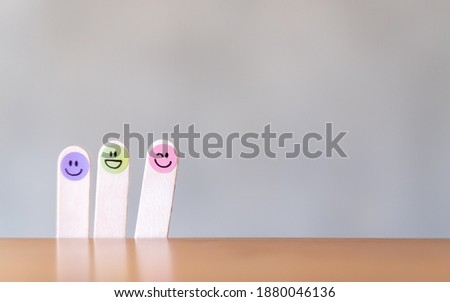 Colorful hand draw happy emotion faces on wooden stick with background