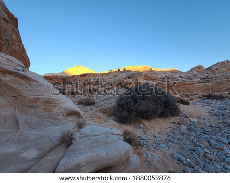 Desert landscape. Sandstones and sunlight hitting moutain top. 