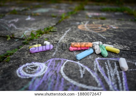 Children's drawing and colored chalks on a tile. Royalty-Free Stock Photo #1880072647