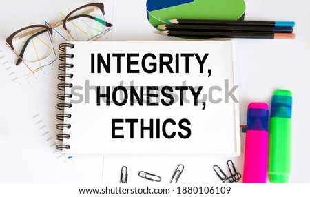 In the notebook, the text of INTEGRITY, HONESTY, ETHICS, a number of highlighters for text, graphics, reports, glasses.