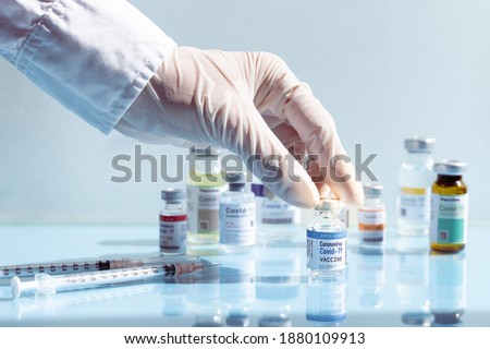 Covid-19 Vaccination Research and Development concept. Hand of a researcher select a potential successful 2019-nCov vaccine vial from among the candidates. COVAX, Promised,  Access to COVID-19 Tools. Royalty-Free Stock Photo #1880109913
