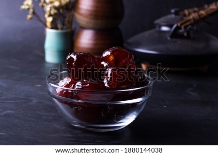 Jujube candied in a beaker on a black background