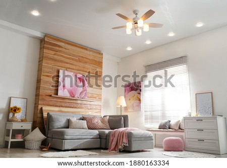 Stylish living room interior with modern ceiling fan and comfortable couch Royalty-Free Stock Photo #1880163334