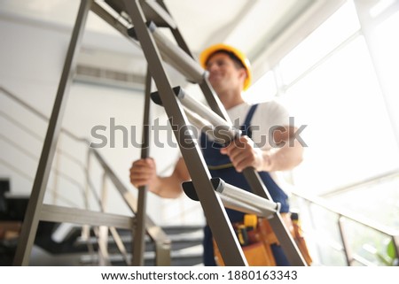 Professional builder with metal ladder on stairs, closeup Royalty-Free Stock Photo #1880163343