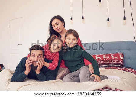 Closeup portrait of cute cheerful family lying down at home, love concept