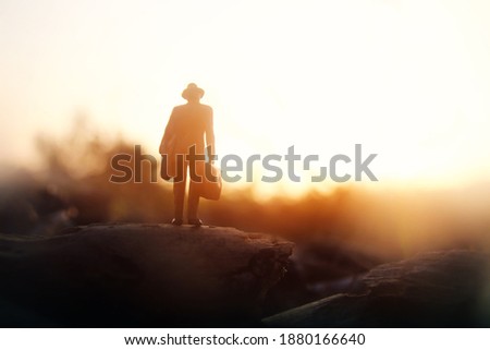 Surreal image of mysterious man walking alone during sunset