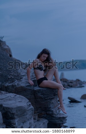 Beautiful brunette woman among the rocks. Selective focus.