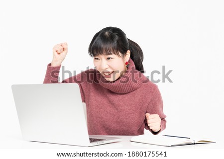 A woman doing a guts pose while using a laptop shot in the studio