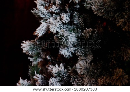 Close-up of Christmas or happy new year tree with decorative elements and artificial snow. Selective focus of Christmas tree in the living room interior. Concept of stylish backgrounds. Copy space
