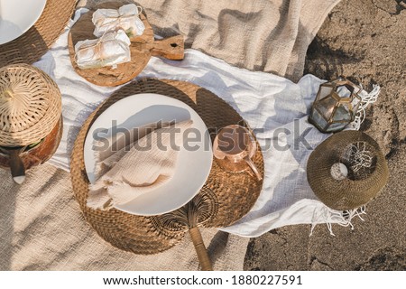 Beautiful summer picnic on the beach at sunset in boho style. Organic fresh ciabatta sandwich on wooden  with natural lemonade on linen blanket. Vegetarian eco idea for weekend picnic.