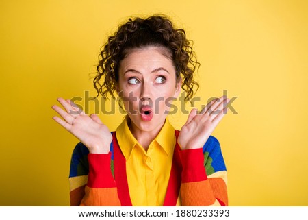 Photo of pretty lady open mouth raise arms listen hear gossip look empty space wear rainbow sweater isolated yellow background