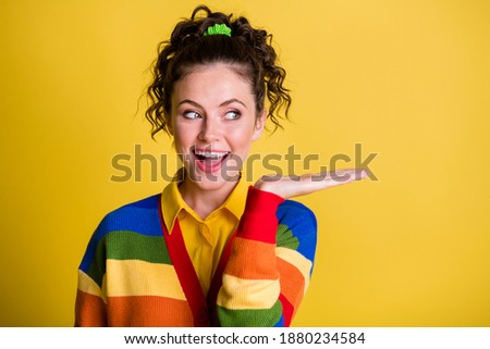 Photo of attractive lady hold open arm look side presenting novelty wear striped sweater isolated yellow color background