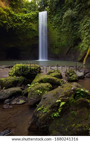 Hidden waterfall in rainforest. Tropical landscape Adventure and travel concept. Nature background. Environment concept. Slow shutter speed, motion photography. Tibumana waterfall Bali, Indonesia