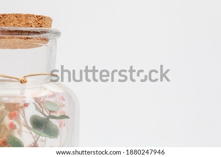 bouquet of dry flowers and potpourri in a glass jar on a white table. High quality photo