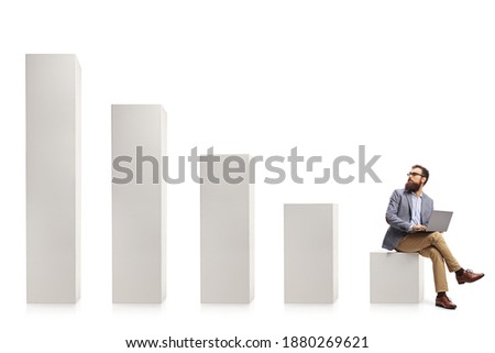 Professional man with a laptop sitting on a column and looking at rising column bars isolated on white background