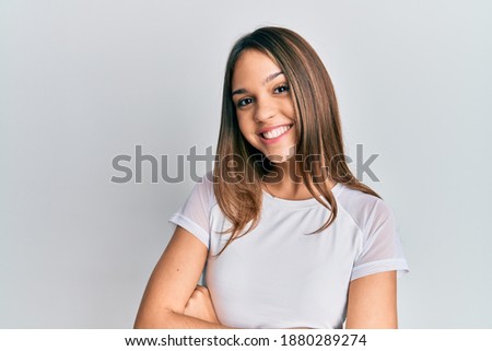 Young brunette woman wearing casual white t shirt happy face smiling with crossed arms looking at the camera. positive person. 