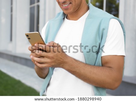 Man using modern mobile phone outdoors, closeup