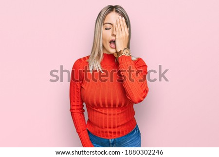 Beautiful blonde woman wearing casual clothes yawning tired covering half face, eye and mouth with hand. face hurts in pain. 