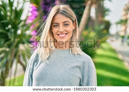 Young blonde girl smiling happy standing at the park