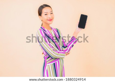 Portrait beautiful young asian woman use smart mobile phone on color isolated background