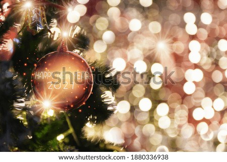 Happy new year 2021 word on red ball decoration on christmas tree on abstract bokeh blurred background. Happiness festive party concept