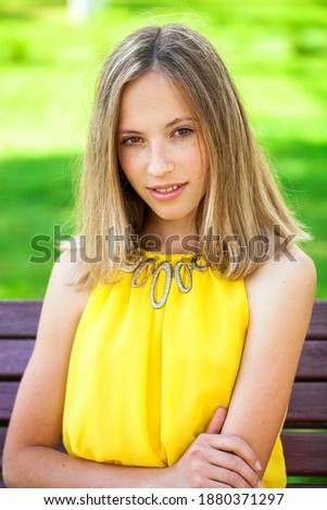 Close up portrait of a young beautiful blonde woman in yellow dress