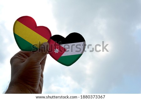 Hand holds a heart Shape Bolivia and Jordan flag, love between two countries