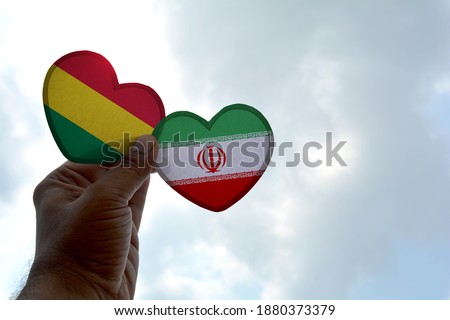 Hand holds a heart Shape Bolivia and Iran flag, love between two countries