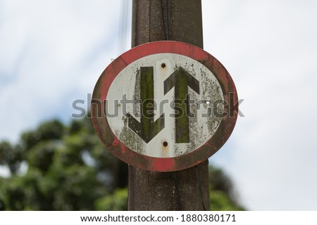 A closeup shot of an old wethered warning traffic sign attached to a street pole