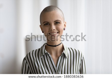 Headshot portrait of attractive millennial bald headed female musician informal person looking at camera with smile. Profile picture of happy stylish young hairless female teenager making video call