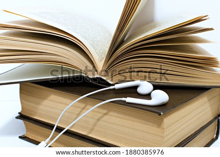 audio headphones on stack of old yellowed hardback books Royalty-Free Stock Photo #1880385976