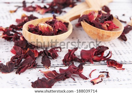 Aromatic dry tea in spoons on wooden background