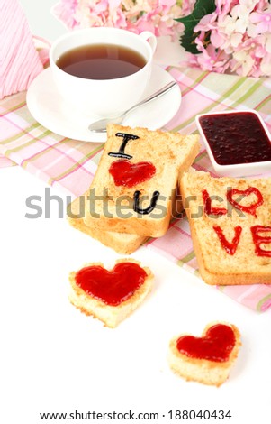 Delicious toast with jam and cup of tea on table close-up