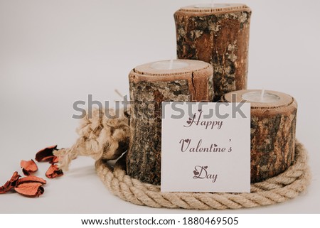 Creative valentine's day or love concept background. Written "Happy Valentine's Day". White background with log wooden candle, dry rose, rope and notepad. Love still life frame concept.