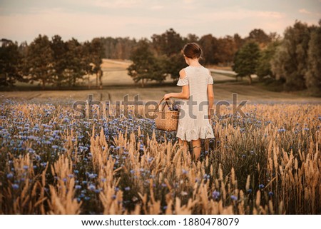 Beautiful picture of girl cutting flowers in the field