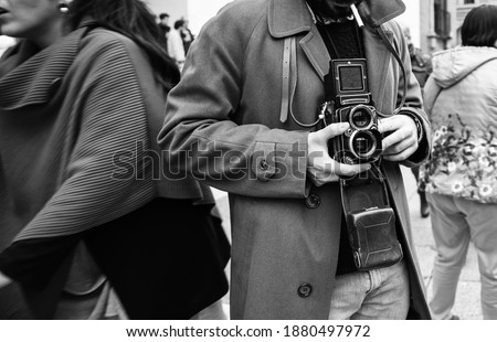 Hipster guy with the vintage camera photographing people in the city - Photojournalist with a famous retro camera taking photo in the crowd during street demonstration - Street photography style  Royalty-Free Stock Photo #1880497972