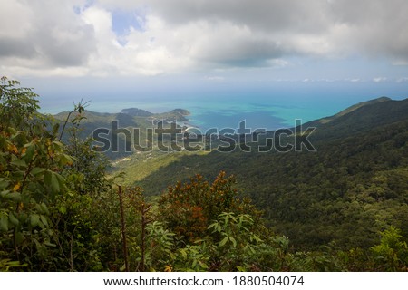 Green bushes on the Khao Ra mountain (national park). View on the Chaloklum beach. Dark gray clouds above.