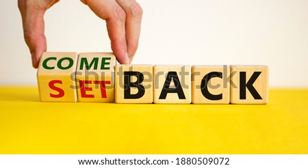 Setback or comeback symbol. Male hand flips wooden cubes and changes the word 'setback' to 'comeback'. Beautiful yellow and white background, copy space. Business and comeback concept.