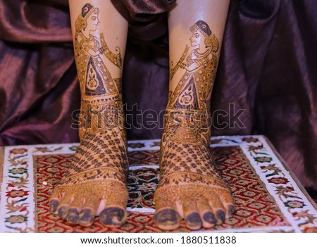 Picture of bridal Mehndi for wedding ceremony. Mehndi on Bride feet on a small height table . Front view and selective area is focused and other is defocused. Beautiful light effect. Selective focus  