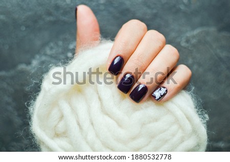 Women's hands with colorful pattern on the nails. 2021 colors trend. Top view. Place for text. Cozy winter design.