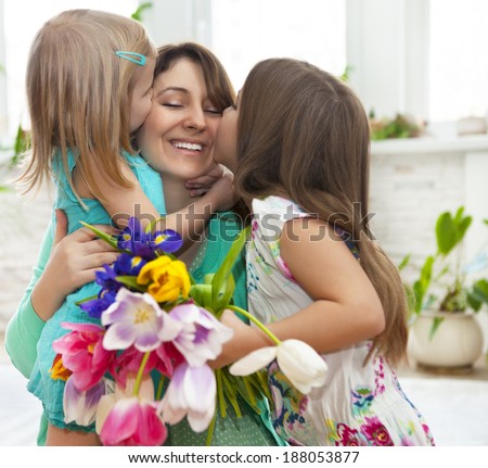Happy woman and her little daughters in the living room. Mother day concept