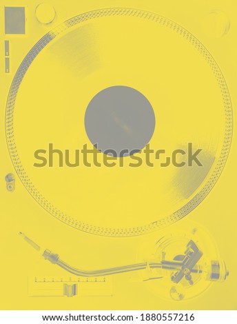 Turntable with vinyl record and stylus, closeup top view. Yellow and gray tone