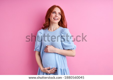 woman enjoying pregnancy, smile, relaxing, hugging belly, isolated on pink background Royalty-Free Stock Photo #1880560045
