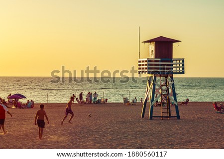 People playing at sunset on a beach in Spain.