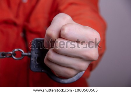 THE HAND OF A TEENAGER IN HANDCUFFS. Concept: juvenile delinquent, criminal liability of minors. Members of youth criminal groups and gangs. Royalty-Free Stock Photo #1880580505