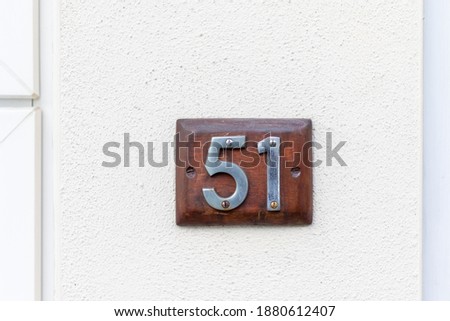 51 on a wooden plaque on a white wall