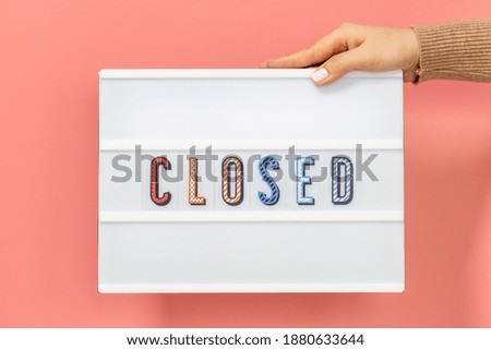 Female hands hold lightbox with inscription closed close-up