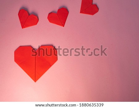 Origami red hearts on pink background. Be my valentine.