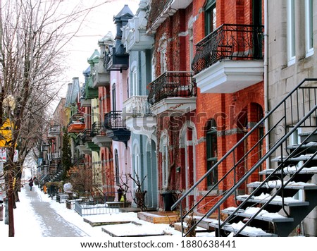 Beautiful houses of old historical Montreal neighborhood Plateau Mont Royal in winter season, bright painted doors. Royalty-Free Stock Photo #1880638441