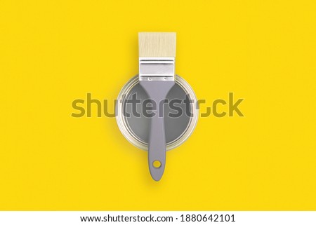 Paint brush with an open can of paint on trendy yellow background. Colors of the year 2021 - Illuminating and Ultimate Grey. Royalty-Free Stock Photo #1880642101